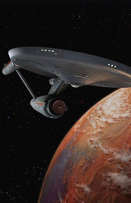 Starship Enterprise flies past a planet